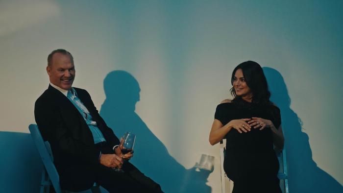 Goodrich Movie: Andy (Michael Keaton) and Grace (Mila Kunis) sit in chairs after a party, Andy holding a glass of wine