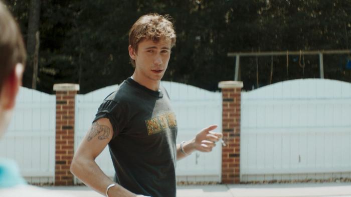 Griffin in Summer movie: Brad (Owen Teague) stands next to a pool, looking at Griffin