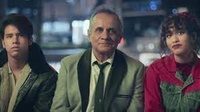 Have a Nice Day: Mexican man in white suit center is flanked by Mexican teenage boy in black leather jacket on left and Mexican teenage girl in red jean jacket on right