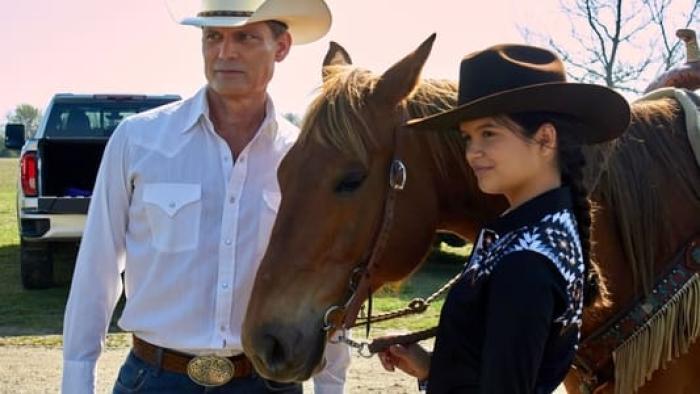 Heart of a Champion: Casper Van Dien and YaYa Gosselin are standing on either side of a horse