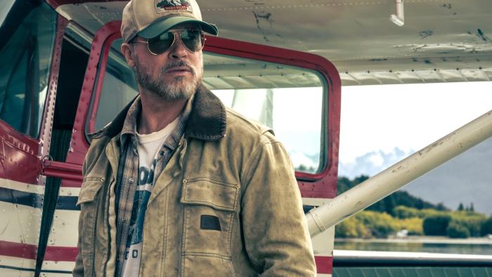 Heart of the Beast movie: James Belmont (Brad Pitt) wears sunglasses while he stands in front of a biplane
