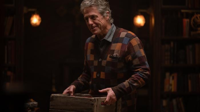 Heretic Movie: Mr. Reed (Hugh Grant), in a checkered sweater, smiles ominously and carries a wooden box