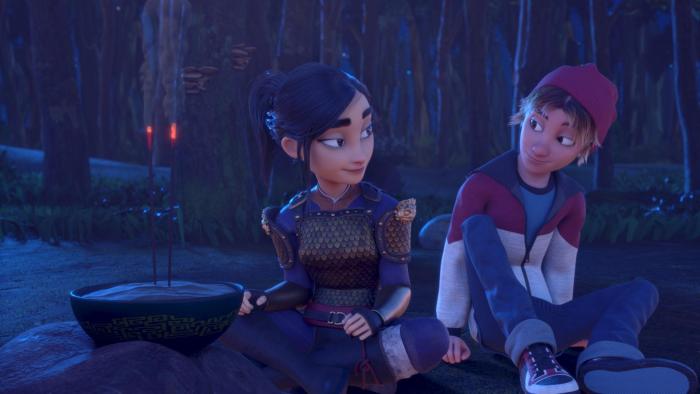 Heroes of the Golden Mask: A White teenage boy in a tracksuit top, red hat, and jeans smiles at a young Asian woman in golden armor as they sit by a shrine with lit incense