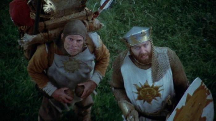 Monty Python and the Holy Grail Movie: Two White men in British medieval clothing look up at the sky