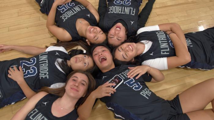 Home Court movie: Six teen girls in uniform jerseys lie on their backs in a circle surrounding Ashley Chea