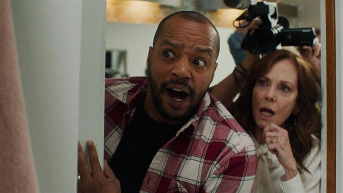 Home Delivery movie: Donald Faison and Lesley Anne Warren peek inside a door with a look of comical shock