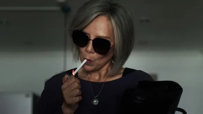 Home for Rent movie: Thai woman in sunglasses center lights a cigarette
