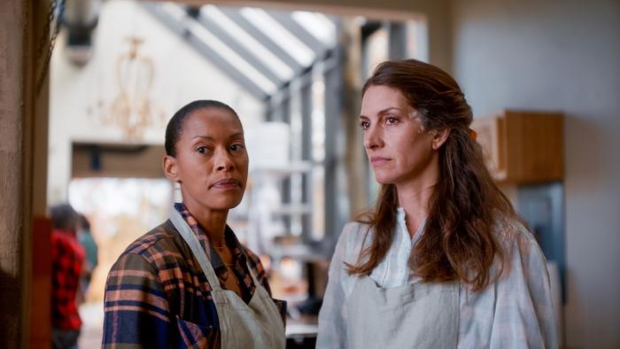 Homestead Movie: Wearing aprons, Tara (Kearran Giovanni) and Jenna (Dawn Olivieri) observe something grimly