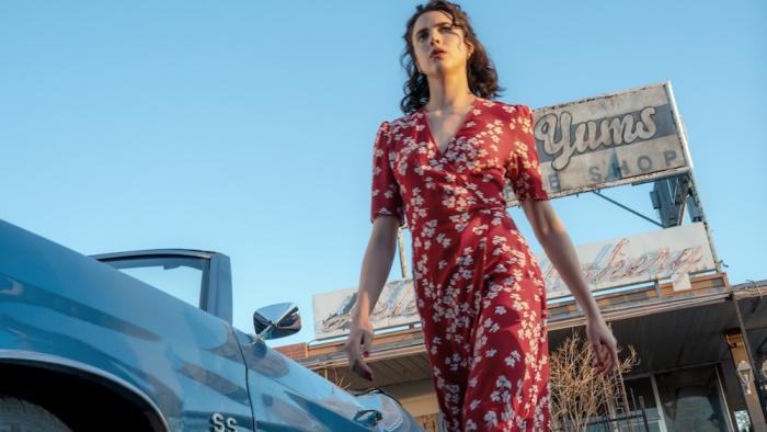 Honey Don't! Movie: Honey (Margaret Qualley), in a red floral dress, strides purposefully from her parked convertible