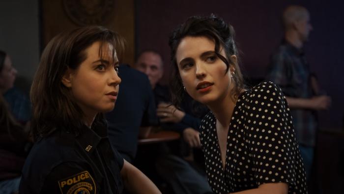 Honey Don't! Movie: Officer MG (Aubrey Plaza) and Honey (Margaret Qualley) lean in to speak to each other\