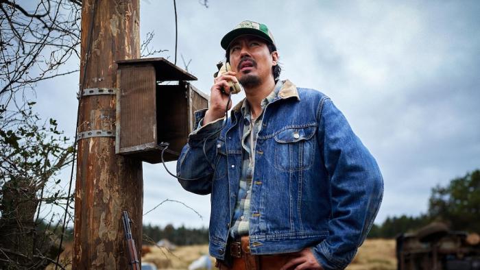 Hope Movie: In a denim jacket and green hat, Sung-ki (Zo In-sung) speaks on a public call box