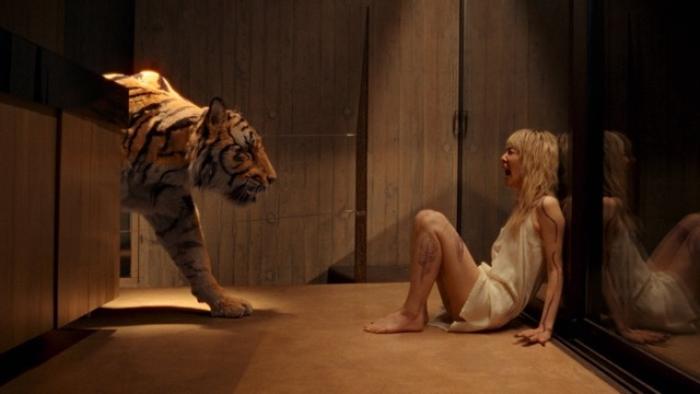 Hot Spot movie: A tiger approaches a woman sitting on the floor in a dimly lit room