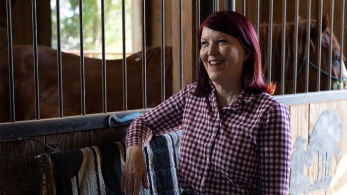 How Hard Can It Be movie: Kate Flannery talks yto Jack Kesy off screen inside of a horse stable