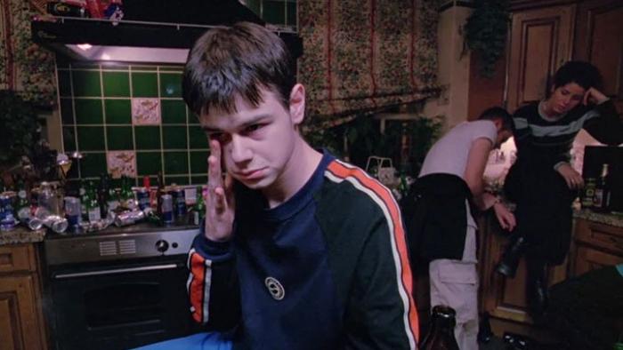 Human Traffic: A young White man experiencing a drugs comedown at a house party with two other party goers behind him