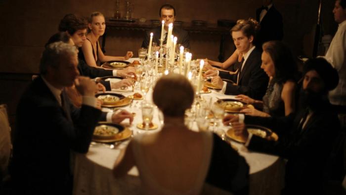 I Am Love: A coupe of people sit at a formal dining table lit by candlelight