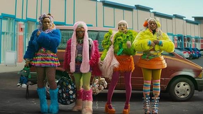 I Love Boosters movie: Four women in colorful, fluffy outfits stand in front of a car