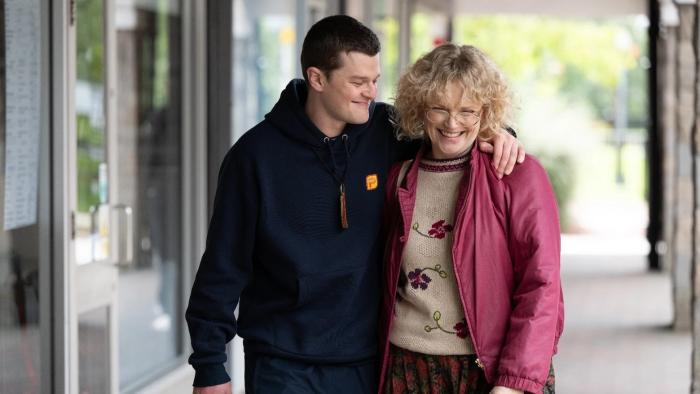 I Swear: Robert Aramayo puts his arm around Maxine Peake as they walk along a high street