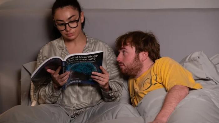 I Want Your Sex movie: Charli XCX reads a medical textbook in bed, with Cooper Hoffman next to her
