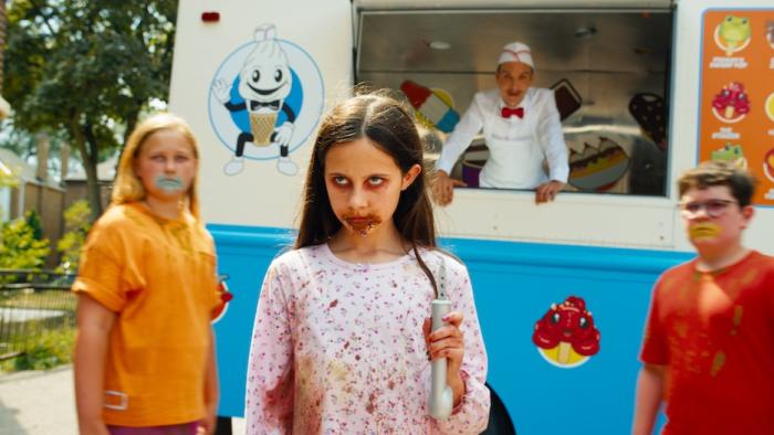Ice Cream Man Movie: A young girl with ice cream on her face holds a pointy weapon next to two other kids near the truck