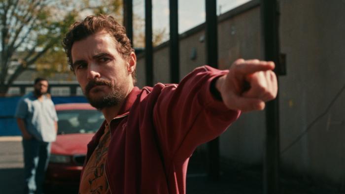 Idiots movie: Dave Franco looks stern and points, with O'Shea Jackson Jr. standing behind him by a red car