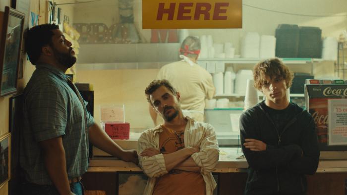 Idiots movie: O'Shea Jackson Jr. leans against a wall, while Dave Franco and Mason Thames lean against a diner counter