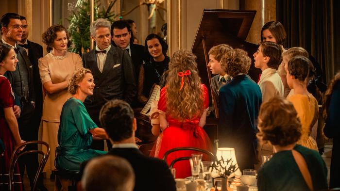 I'll Find You Movie: Connie Nielsen plays the piano at a gathering while lovingly looking at a boy who's singing
