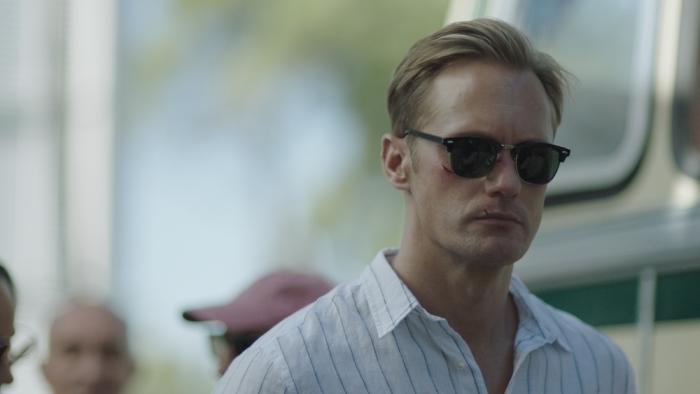 Infinity Pool Movie: Alexander Skarsgard wearing sunglasses, his face cut up