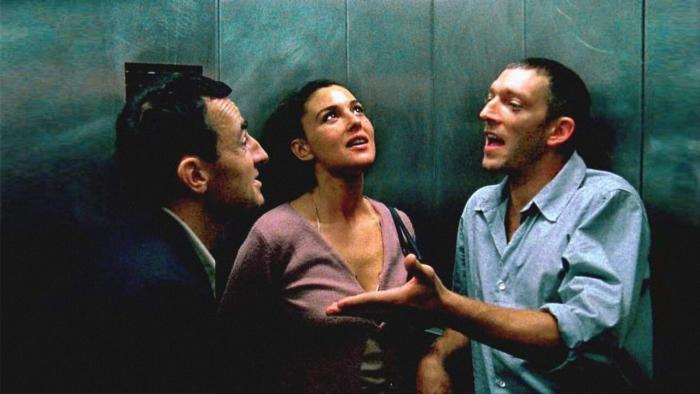 Irreversible: Two men and a woman in an elevator look upward with concerned expressions against teal-colored walls
