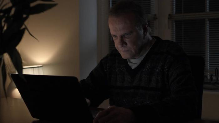 It's Not Over movie: Christopher Lambert sits in front of a laptop in an office