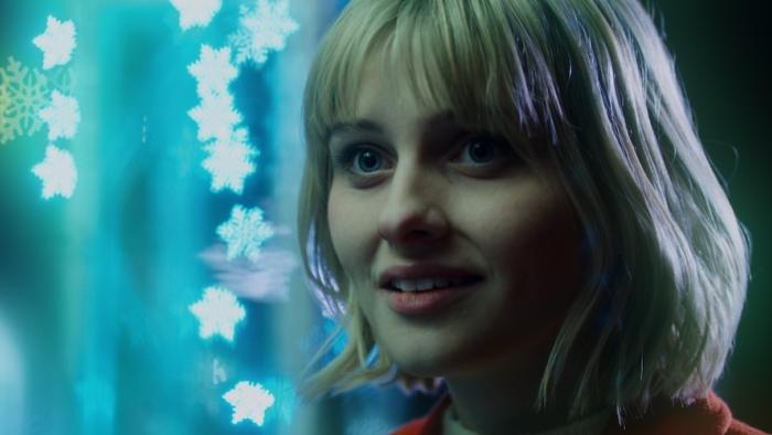 It's a Wonderful Knife Movie: Winnie Carruthers (Jane Widdop) stands in front of twinkling Christmas lights and smiles