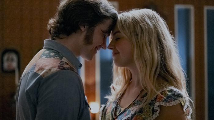 Jesus Revolution Movie: Joel Courtney as Pastor Greg Laurie and Anna Grace Barlow as Cathe smile as they embrace with their foreheads touching