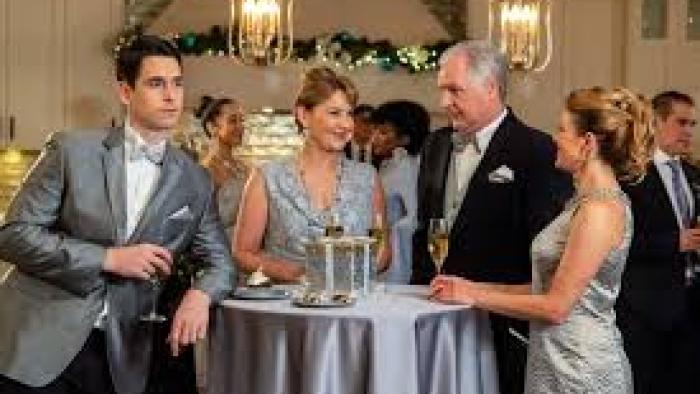 Joy for Christmas: Dressed-up couples stand around a table