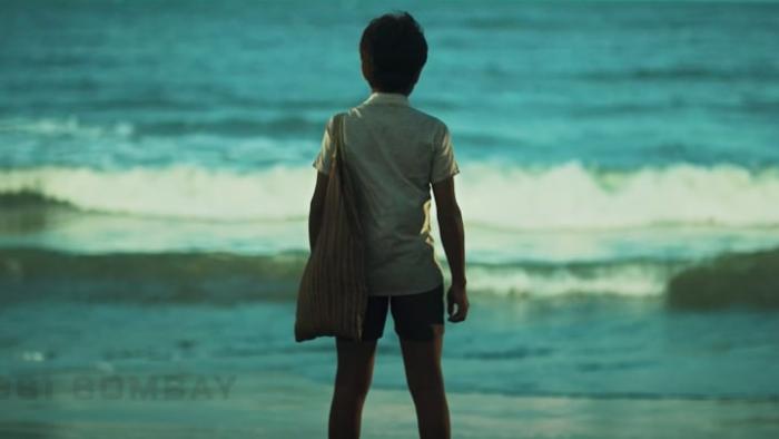 K.G.F -- Chapter 1: A young boy has his back to camera while looking out at the waves crashing in the sea