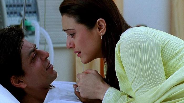 Kal Ho Naa Ho: Aman lies on a hospital bed and Naina sits beside him, leaning in; both characters are emotional