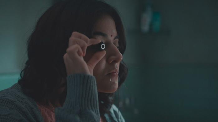 Khufiya: An Indian woman inspects a hidden camera lens.