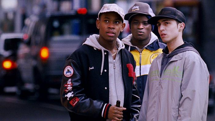 Kidulthood: Three teenage boys wearing jackets and caps stand on a city street