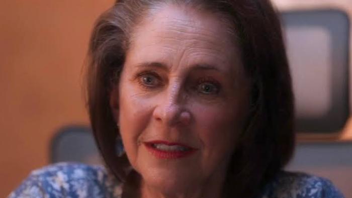 Kill. Bury. Print. movie: Smiling woman in a blue patterned shirt.