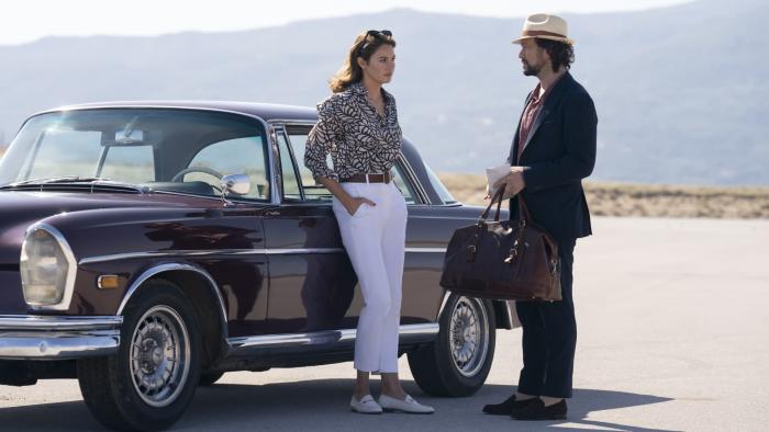 Killer Heat: Shailene Woodley leans against a car with her hands in her pockets talking to Joseph Gordon-Levitt, with Cretan mountains behind them