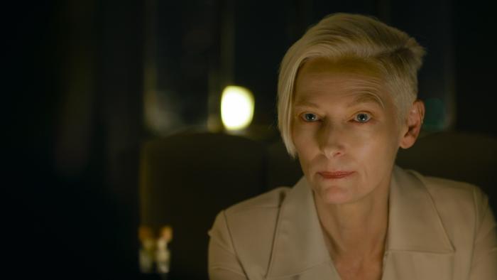 The Killer Movie: The Expert (Tilda Swinton) is seen at a restaurant, where the Killer finds her