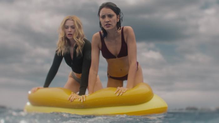 Killer Whale Movie: Maddie and Trish are perched atop a yellow float, looking at something in the water