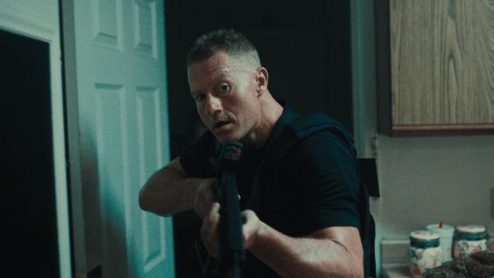King Ivory Movie: Holding a rifle at the ready, Layne (James Badge Dale) carries a rifle while searching a house for drug dealers