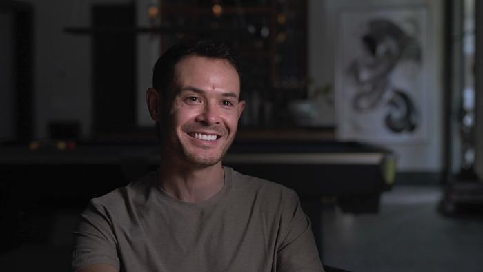 Kyle Larson vs. The Double movie: Kyle Larson smiles while sitting on a couch for an interview