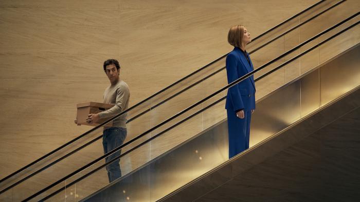 Ladies First: Sacha Baron Cohen and Rosamund Pike on an escalator.