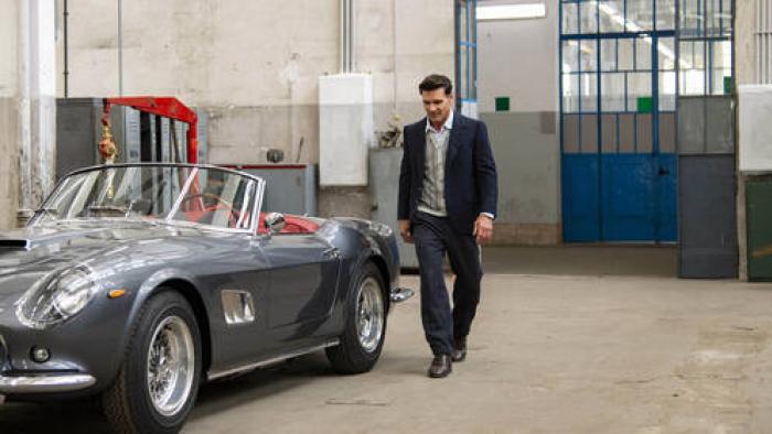 Lamborghini: The Man Behind The Legend: a smartly dressed middle-aged Italian man stands by a grey vintage sports car in a workshop