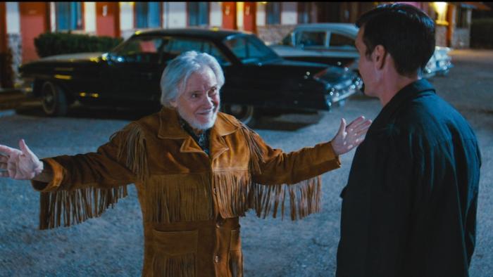 Laws of Man Movie: Preacher Cassidy Whittaker (Harvey Keitel) spreads his arms as he speaks to Frank (whose back is to viewers)