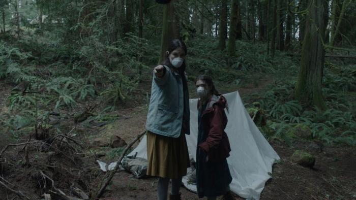 Lazareth movie: Sarah Pidgeon stands next to Katie Douglas in face masks, holding out a knife