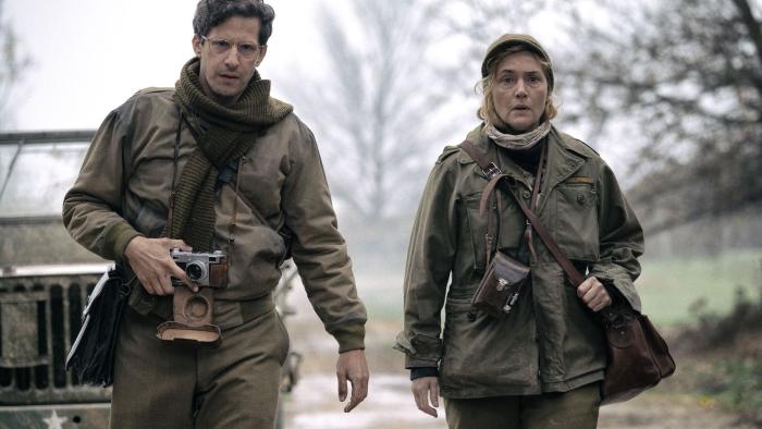 Lee movie: David (Andy Samberg) and Lee (Kate Winslet) walk with cameras while dressed in Army-issued clothes