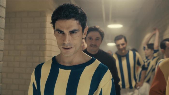 Lefter: The Story of Ordinarius movie: Turkish men soccer players in blue/yellow striped jerseys walk down hall getting ready to play a soccer match