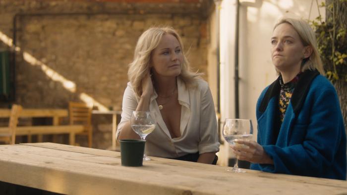 Let's Love: Malin Akerman and Jess Weixler sit together drinking in a pub garden