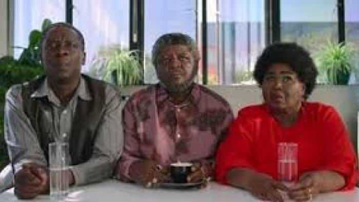 Lobola Man: A Black man and 2 Black women sit 